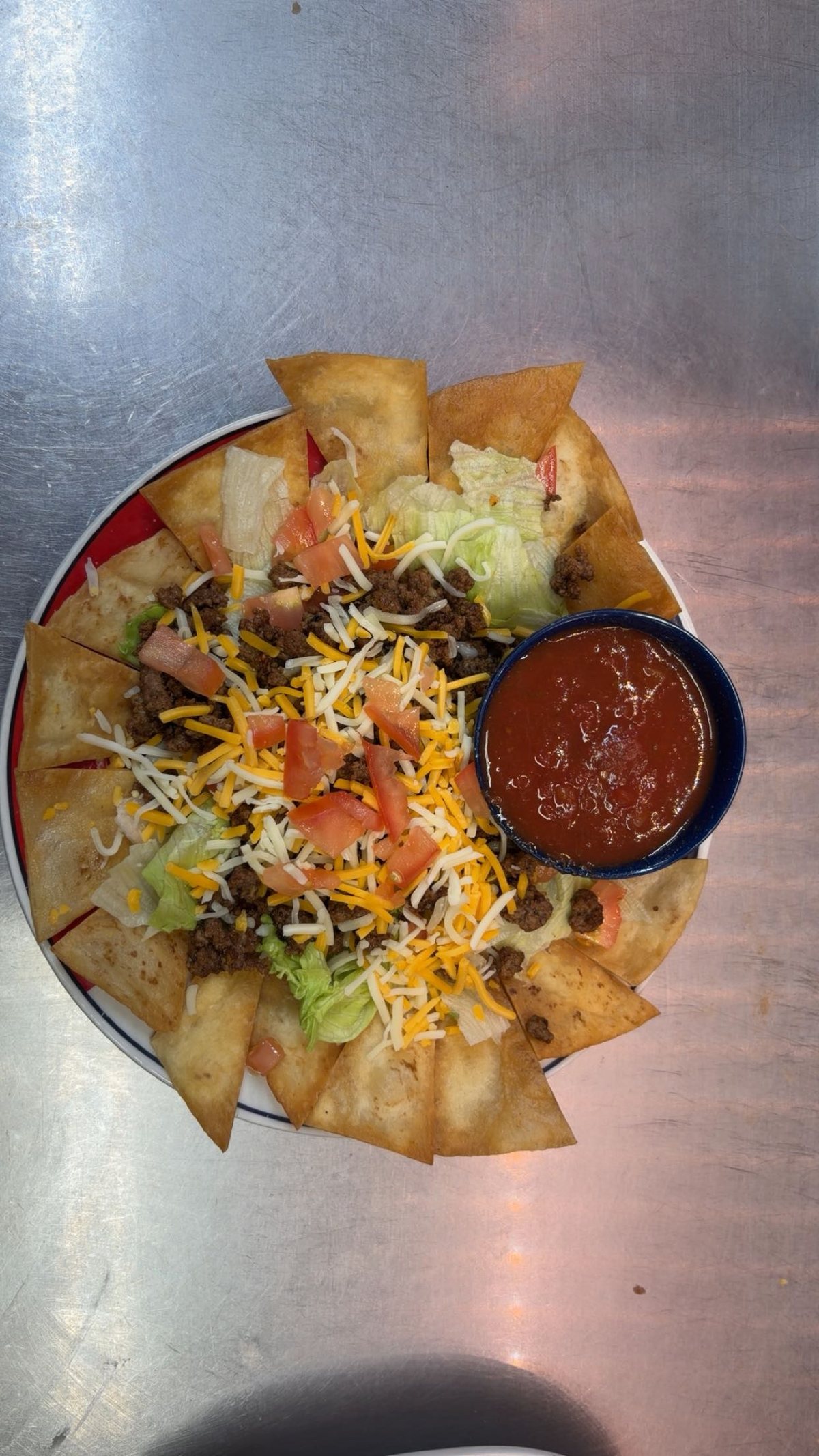 Taco salad with seasoned beef, cheese, tomato and tortilla chips
